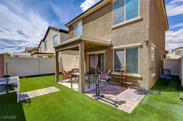 6231 Portland Treaty Ave, Las Vegas, NV 89122 - back of property with a lawn, a fenced backyard, a patio area, and stucco siding