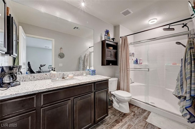 6231 Portland Treaty Ave, Las Vegas, NV 89122 - full bathroom with a stall shower, toilet, wood finished floors, and visible vents