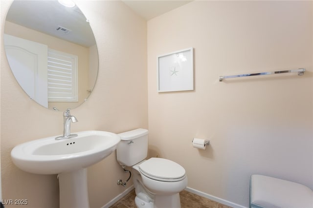 bathroom featuring baseboards, toilet, and visible vents