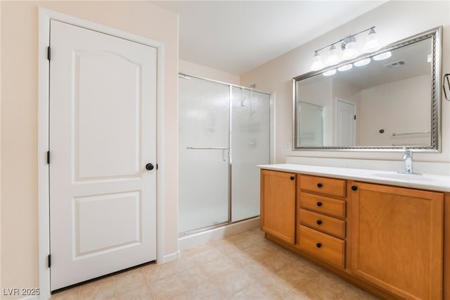 bathroom featuring visible vents, a stall shower, and vanity