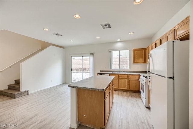 4045 Oliver Sagebrush Dr, Las Vegas, NV 89122 - kitchen featuring a sink, light wood-style floors, white appliances, and visible vents