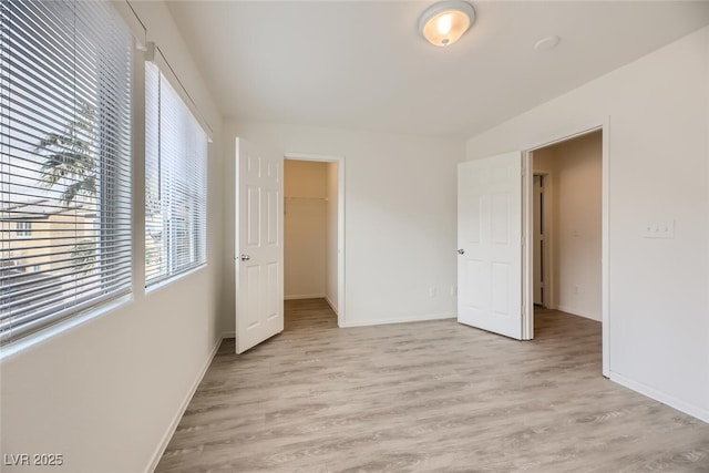 4045 Oliver Sagebrush Dr, Las Vegas, NV 89122 - unfurnished bedroom featuring light wood-type flooring, baseboards, a spacious closet, and multiple windows