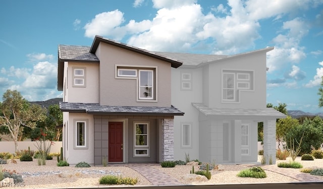 view of front facade with a mountain view, stucco siding, stone siding, and fence