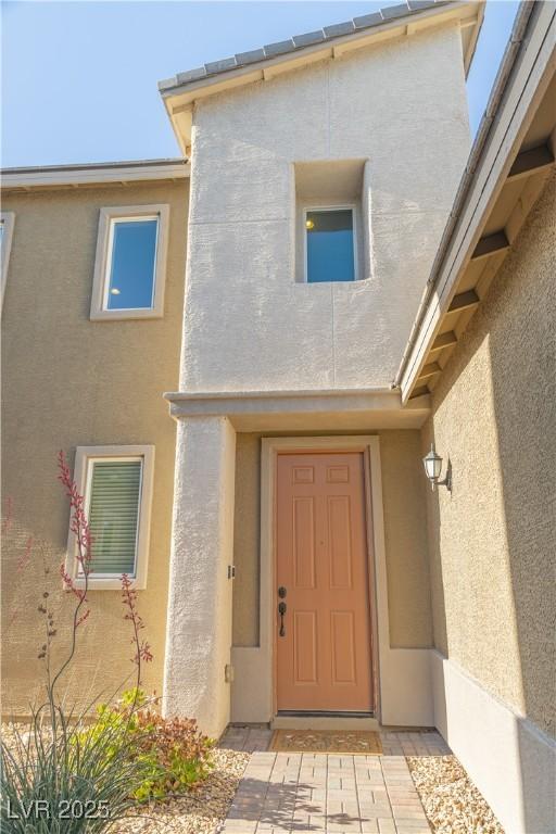 entrance to property featuring stucco siding