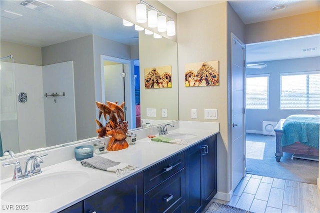 bathroom with a sink, ensuite bathroom, double vanity, and visible vents