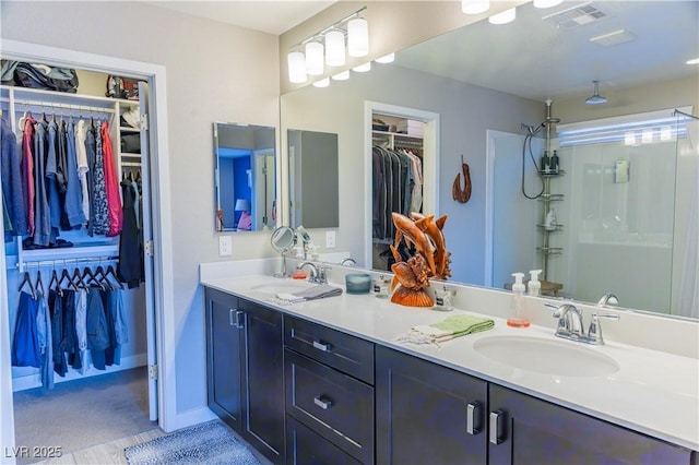 full bathroom with double vanity, visible vents, a sink, and a spacious closet