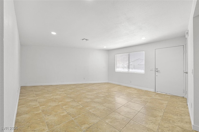 unfurnished room featuring baseboards, recessed lighting, a textured ceiling, and visible vents
