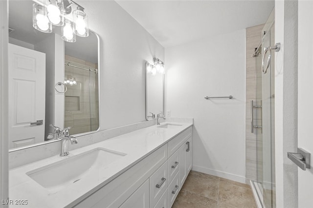 bathroom featuring double vanity, baseboards, a sink, and a stall shower