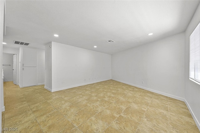 spare room featuring baseboards, recessed lighting, and visible vents