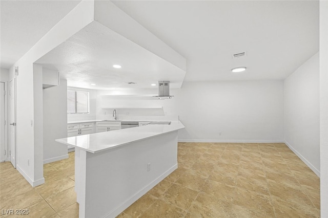 kitchen with light countertops, a peninsula, baseboards, recessed lighting, and visible vents