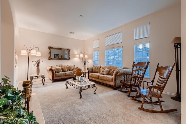 6750 Quapaw St, Las Vegas, NV 89149 - living area with visible vents, carpet flooring, arched walkways, and a healthy amount of sunlight
