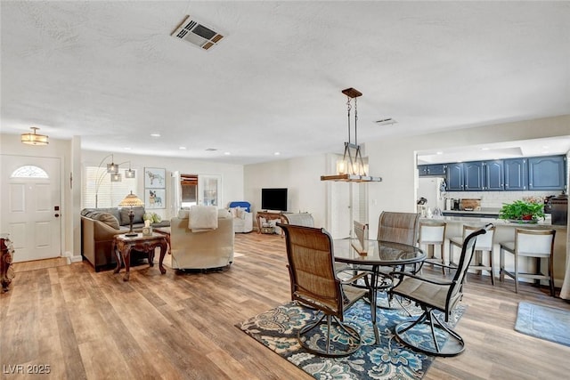 dining area featuring visible vents, a healthy amount of sunlight, and light wood-type flooring