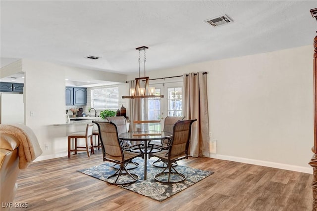 dining room with baseboards, visible vents, and light wood-style flooring