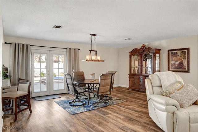 dining room featuring french doors, wood finished floors, and visible vents