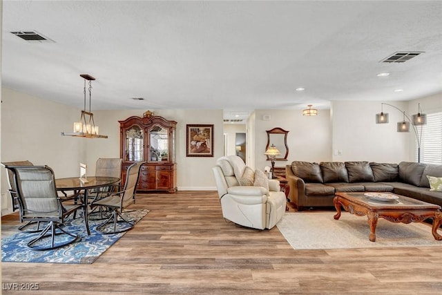 living room with visible vents, recessed lighting, and wood finished floors