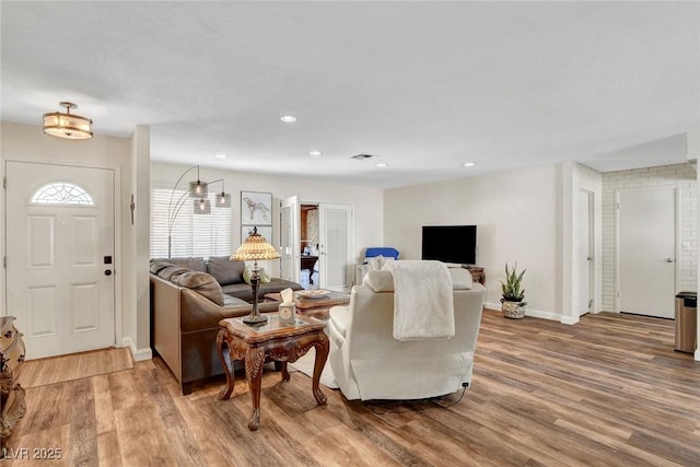 living area with recessed lighting, baseboards, visible vents, and wood finished floors