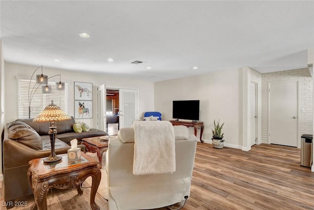 living room featuring recessed lighting, baseboards, visible vents, and wood finished floors