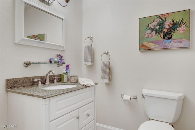 bathroom featuring toilet, baseboards, and vanity