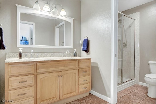 bathroom featuring a sink, tile patterned flooring, double vanity, toilet, and a shower stall