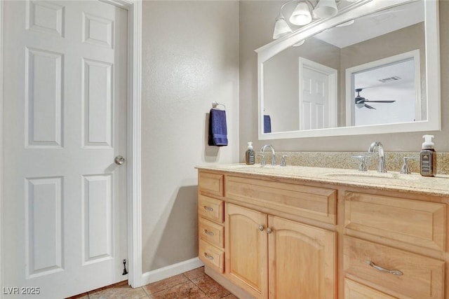 bathroom with double vanity, a sink, baseboards, and tile patterned flooring