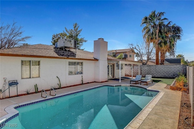 view of pool with a patio, fence, central AC unit, and a fenced in pool