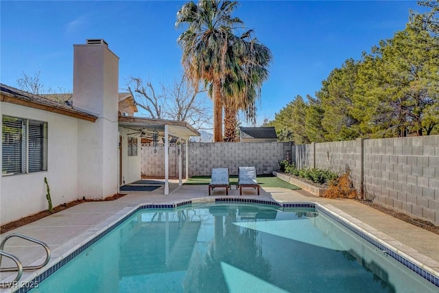 view of swimming pool with a fenced backyard, a fenced in pool, ceiling fan, and a patio area