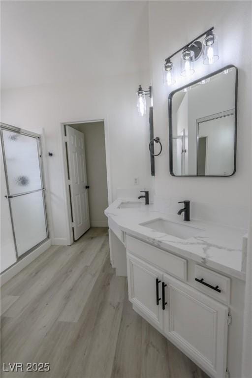 4416 Inez Dr, Las Vegas, NV 89130 - bathroom with double vanity, a shower stall, a sink, and wood finished floors