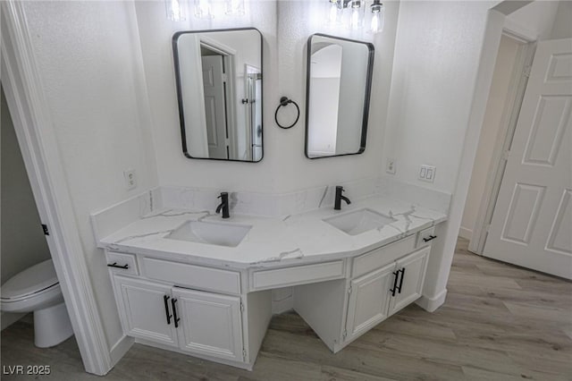 4416 Inez Dr, Las Vegas, NV 89130 - bathroom with double vanity, toilet, a sink, and wood finished floors