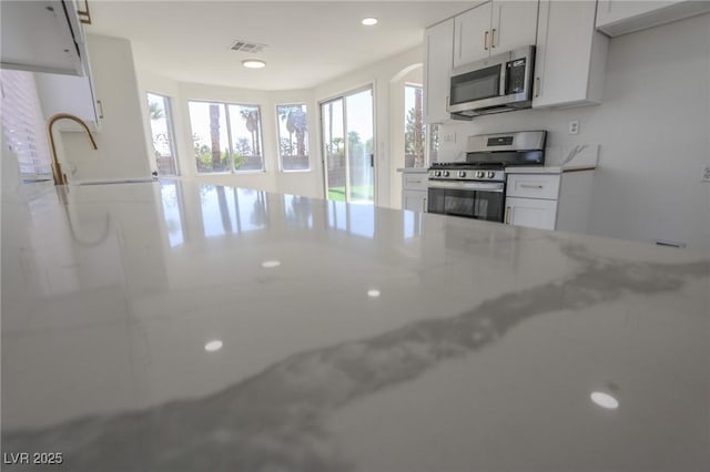 4416 Inez Dr, Las Vegas, NV 89130 - kitchen featuring visible vents, recessed lighting, white cabinetry, a sink, and appliances with stainless steel finishes