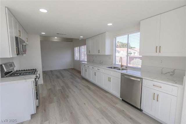 4416 Inez Dr, Las Vegas, NV 89130 - kitchen featuring visible vents, a sink, light wood-style floors, stainless steel appliances, and white cabinetry