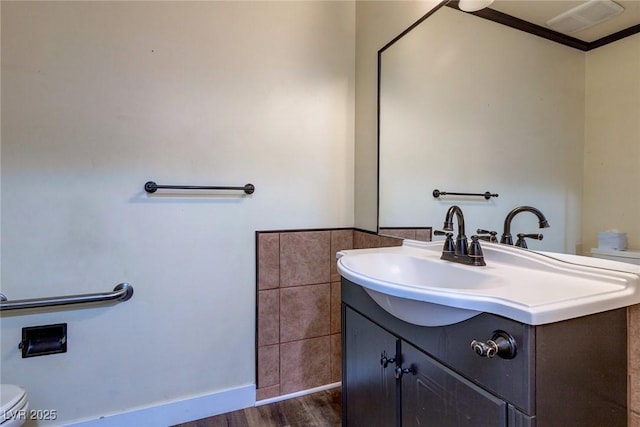 half bathroom featuring vanity, toilet, and wood finished floors