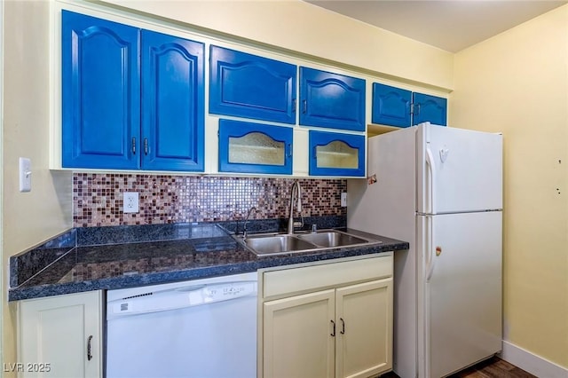 kitchen featuring decorative backsplash, blue cabinetry, dark countertops, a sink, and white appliances