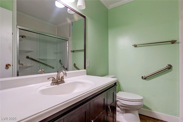 bathroom with vanity, ornamental molding, a shower with door, and toilet