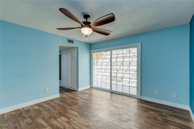 spare room with a ceiling fan, baseboards, visible vents, and wood finished floors