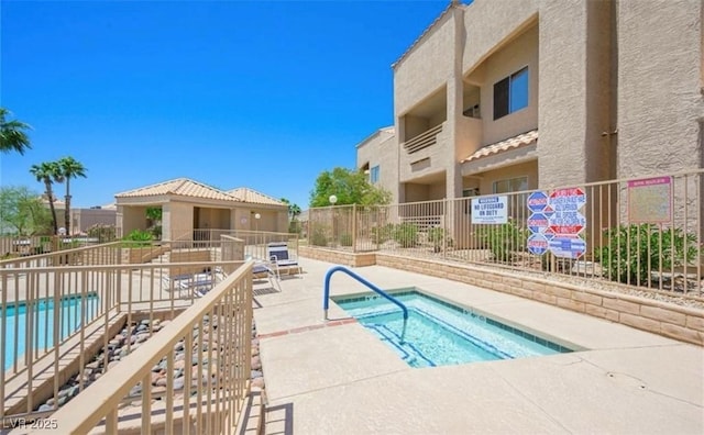 pool featuring a patio, a hot tub, and fence