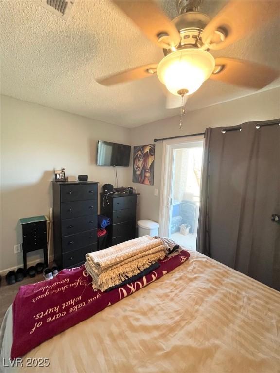 bedroom with ceiling fan, access to outside, a textured ceiling, and visible vents