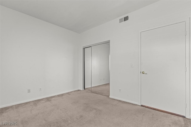 unfurnished bedroom featuring visible vents, carpet flooring, baseboards, and a closet