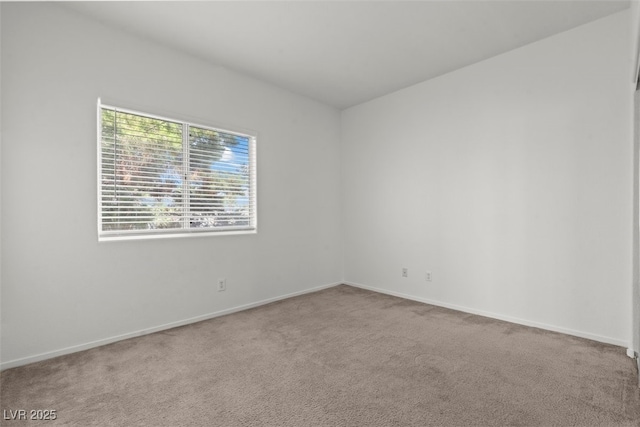 carpeted empty room featuring baseboards