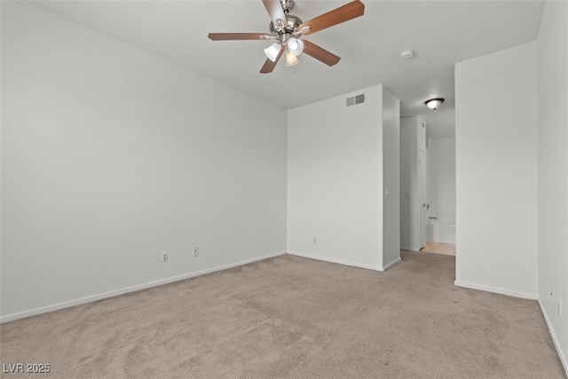 empty room featuring light colored carpet, baseboards, ceiling fan, and visible vents