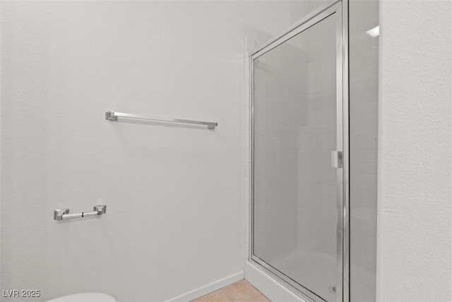 full bathroom featuring tile patterned flooring, toilet, and a shower stall