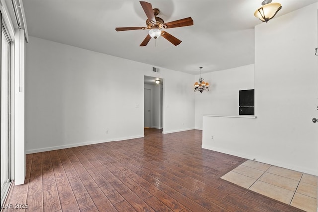 interior space with baseboards, visible vents, wood finished floors, and ceiling fan with notable chandelier