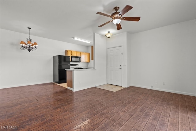 unfurnished living room featuring baseboards, ceiling fan with notable chandelier, and wood finished floors