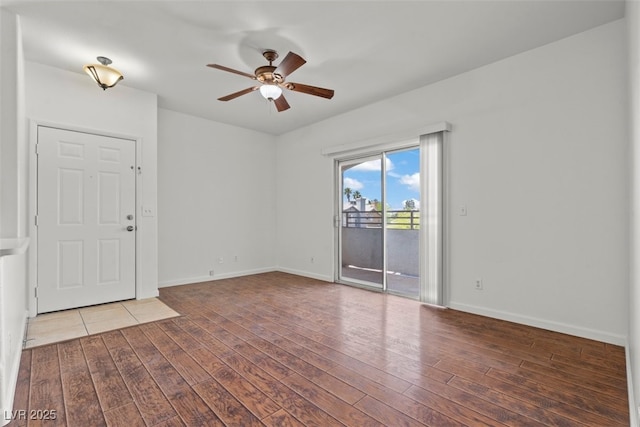 empty room with baseboards, a ceiling fan, and wood finished floors