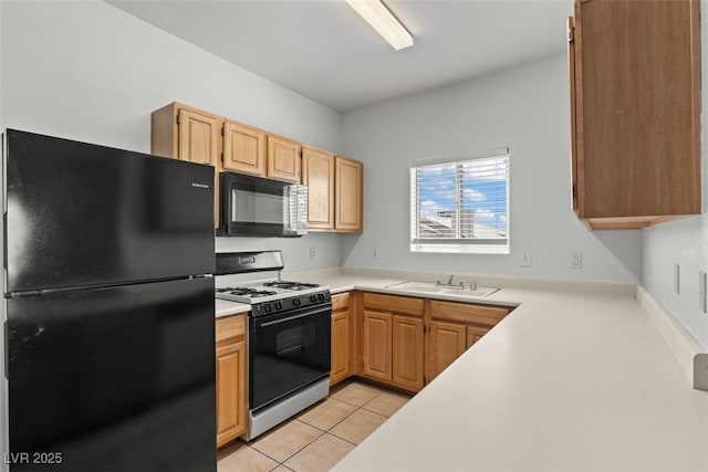 kitchen featuring a sink, light brown cabinets, light countertops, light tile patterned floors, and black appliances