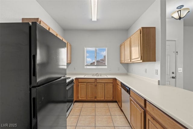 kitchen featuring range, stainless steel dishwasher, light countertops, light tile patterned floors, and freestanding refrigerator