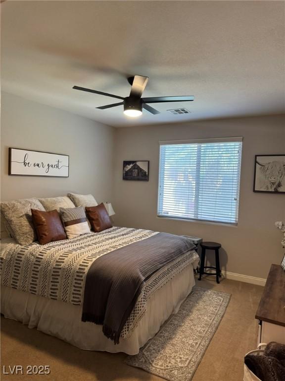 carpeted bedroom featuring a ceiling fan, baseboards, and visible vents