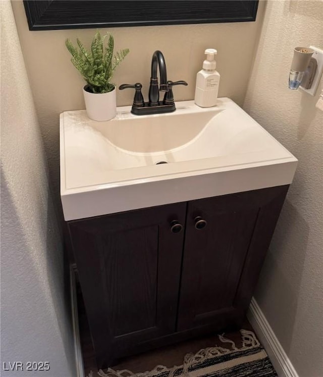 bathroom with vanity and a textured wall
