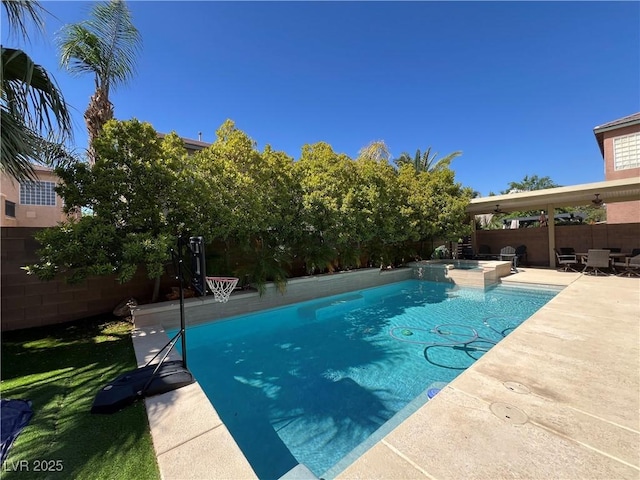 view of swimming pool featuring a fenced backyard, a pool with connected hot tub, and a patio area