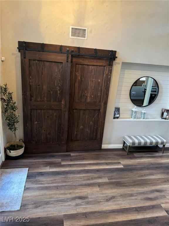 interior space with baseboards, visible vents, and wood finished floors