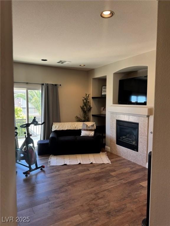 living room featuring visible vents, recessed lighting, wood finished floors, and a tile fireplace